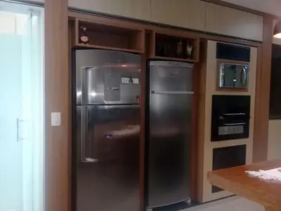 Cozinha planejada: nicho sob medida para geladeira e torre de fornos