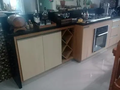 Cozinha planejada: balcão com portas e adega em madeira
