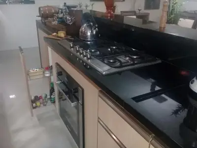 Cozinha planejada: bancada com cooktop e forno embutido