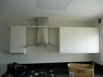 Cozinha planejada: armários aéreos brancos com coifa