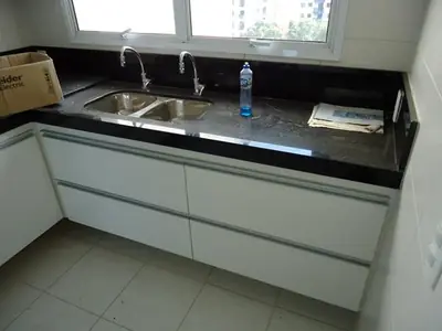 Cozinha planejada: balcão em L sob bancada de granito