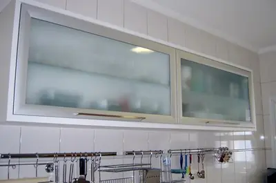 Cozinha planejada: armário aéreo com portas de vidro jateado