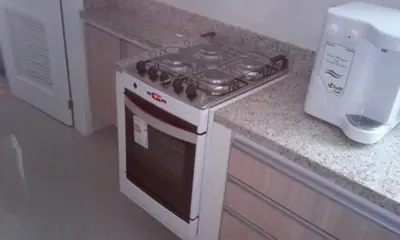 Cozinha planejada: balcão em tom madeira ao lado do fogão