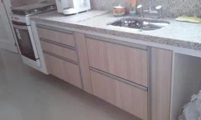 Cozinha planejada: gavetas e portas sob bancada de granito