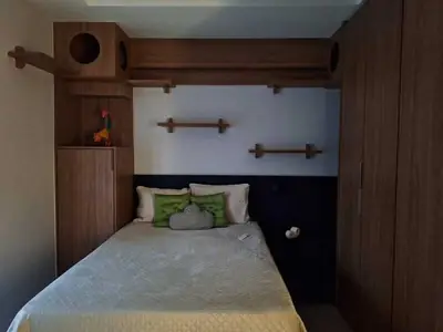 Dormitório planejado: cabeceira, nichos e guarda-roupa em tom amadeirado
