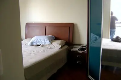 Dormitório planejado: cabeceira em madeira e porta de correr