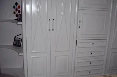 Dormitório planejado: guarda-roupa branco com portas trabalhadas e gaveteiro