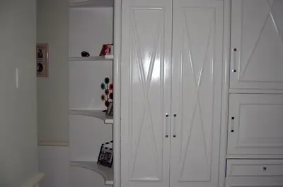 Dormitório planejado: guarda-roupa branco com prateleiras de canto