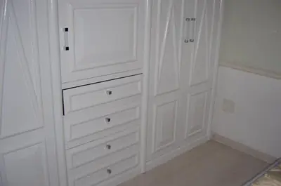 Dormitório planejado: armário branco com gavetas
