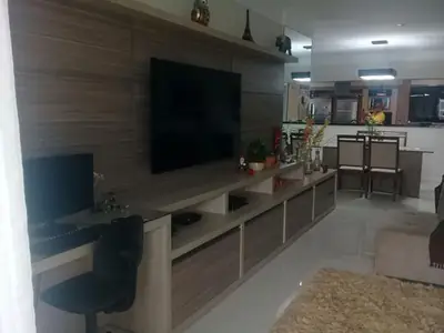 Home theater planejado: painel para TV e rack em tom amadeirado