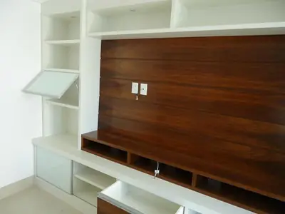 Home theater planejado: painel em madeira com nichos e prateleiras brancas