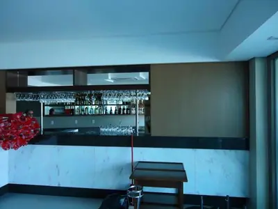 Móvel planejado para comércio: balcão de bar com prateleiras ao fundo